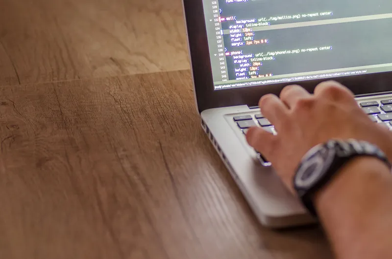 A laptop screen displaying application code being reviewed