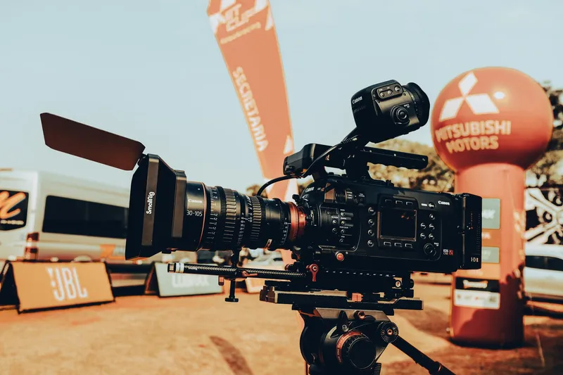A video camera set up in front of an advertisement backdrop