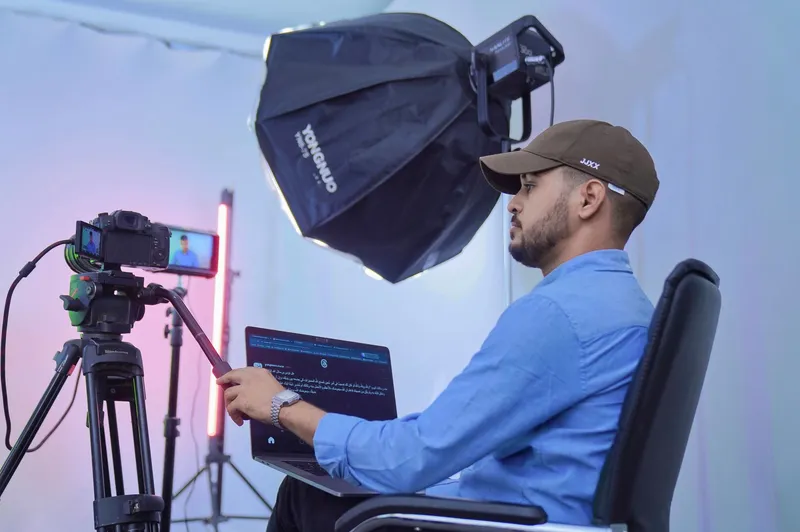 A camera operator filming in a video production studio